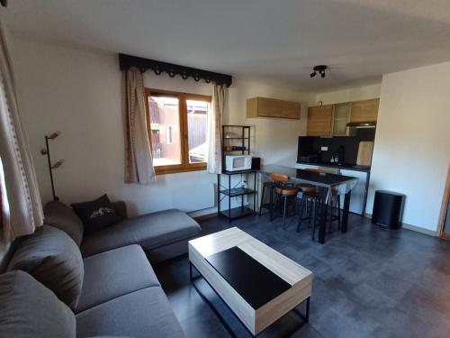 un salon avec un canapé et une table dans l'établissement Appartement 4-6 Personnes - Piscines - SAMOENS - HAUTE SAVOIE, à Samoëns