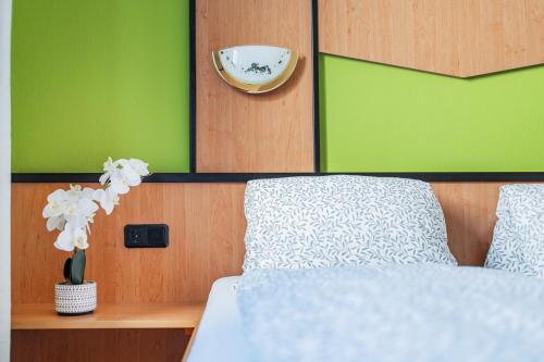 a bedroom with a bed and a vase with flowers at Vienna West Business Inn in Vienna