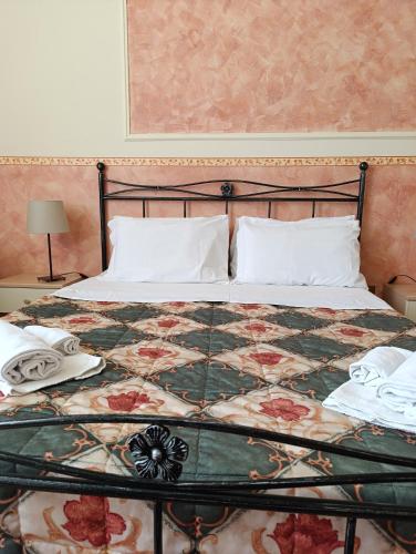 a bed with a quilt and two pillows on it at Hostel il Tetto in Melfi