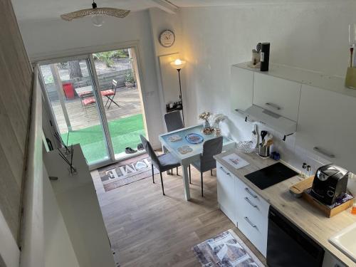 Maison dans la Pinède à Lacanau في لاكانو: مطبخ مع طاولة وغرفة طعام مع اطلالة