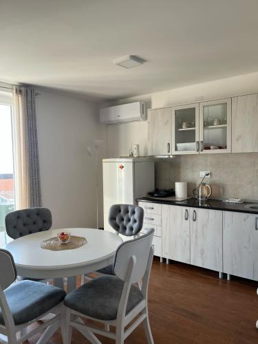 a kitchen with a white table and chairs in a room at Surčin Apartment in Ledine