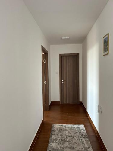 an empty hallway with a door and a rug at Surčin Apartment in Ledine