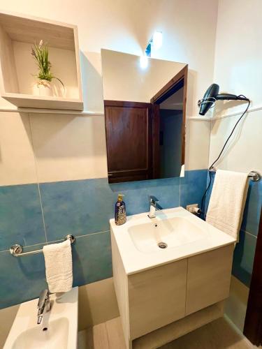 a bathroom with a sink and a mirror at La Pavoncella Holiday Home in San Vito