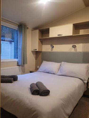 a bedroom with a large white bed with towels on it at Sapphire in Saint Leonards