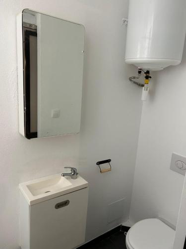 a white bathroom with a sink and a mirror at Studio 201 - Grand Cerf - Metz hyper centre - 2ème étage in Metz