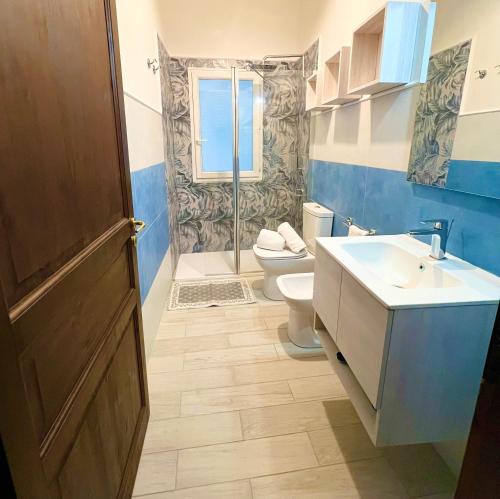 a bathroom with a toilet and a sink and a shower at La Pavoncella Holiday Home in San Vito