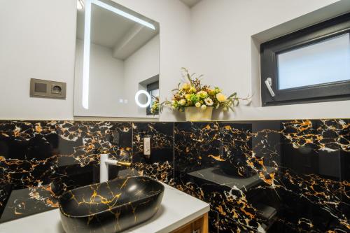 a bathroom with a black and gold patterned wall at La Borsanu in Năsăud