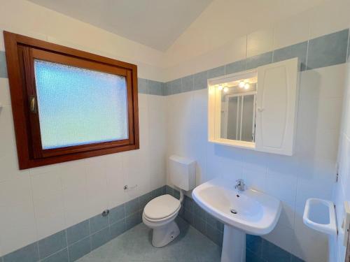 Villa Milly في لينانو سابيادورو: حمام مع مرحاض ومغسلة ونافذة