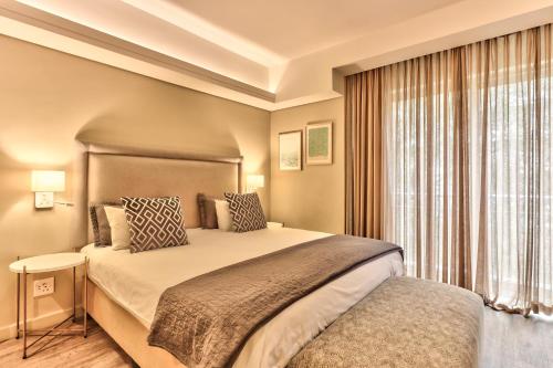 a bedroom with a large bed and a window at WINK Aparthotel Foreshore in Cape Town