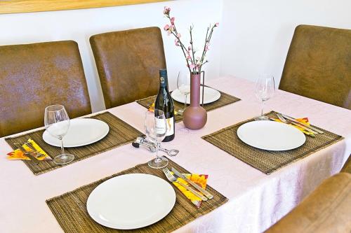 a table with two white plates and a bottle of wine at Harmony - with jacuzzi and sauna in Donji Zvečaj