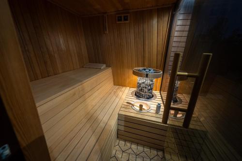 a small sauna with a wooden floor and a chair at Harmony - with jacuzzi and sauna in Donji Zvečaj