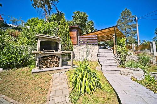 a stone oven in a garden with a house at Harmony - with jacuzzi and sauna in Donji Zvečaj