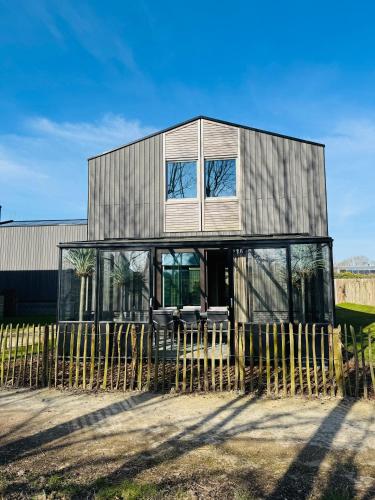 a house with glass windows and a fence at Parc La Dune Marrakesh Lodge in Warmenhuizen