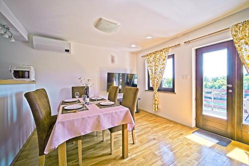 a dining room with a table and some chairs at Harmony - with jacuzzi and sauna in Donji Zvečaj