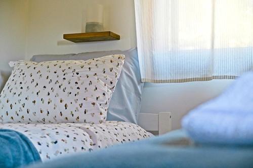 a bed with a white pillow and a window at Harmony - with jacuzzi and sauna in Donji Zvečaj