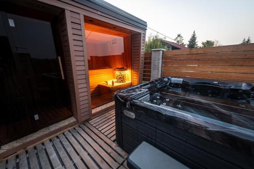 a hot tub on the deck of a house at Harmony - with jacuzzi and sauna in Donji Zvečaj
