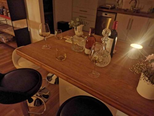 a wooden table with wine glasses and bottles on it at OneWorldLove Garden in Woy Woy