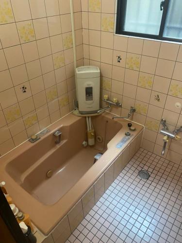 a bath tub with a water tank in a bathroom at 静佳民宿 in Osaka