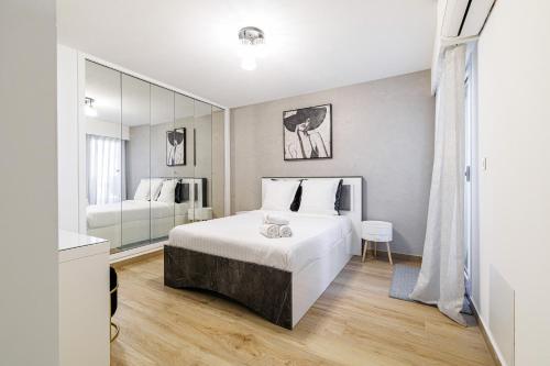 a bedroom with a large white bed and a mirror at Le Mediterranée-centre-climatisation in Menton
