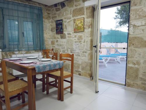 ein Esszimmer mit einem Tisch und Stühlen sowie eine Terrasse in der Unterkunft Marina's Cottage in Lagolíon