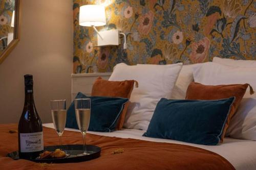 - un lit avec 2 verres de champagne et une bouteille de vin dans l'établissement My Boudoir, à Paris