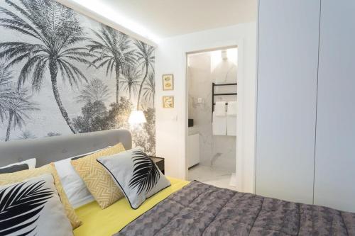 - une chambre avec un lit et une fresque murale de palmiers dans l'établissement La Boutique du Sentier, à Paris