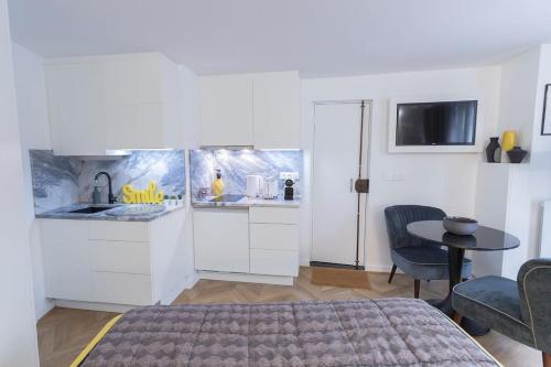 une chambre avec un lit et une table et une cuisine dans l'établissement La Boutique du Sentier, à Paris