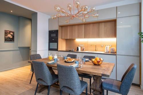 ein Esszimmer mit einem Holztisch und Stühlen in der Unterkunft My Cottage in Paris in Paris