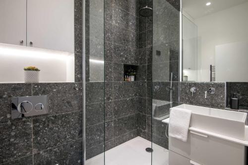 une salle de bain avec douche et lavabo dans l'établissement My Opéra II, à Paris