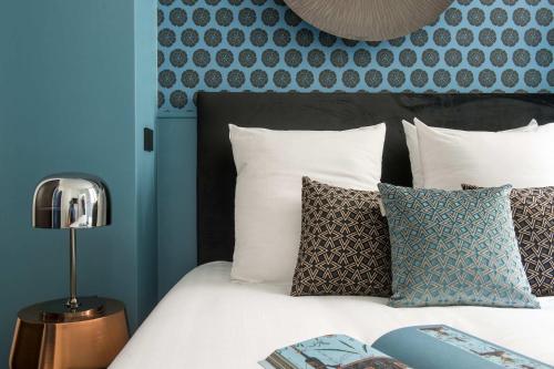 - une chambre avec un lit doté d'une tête de lit et d'oreillers bleus dans l'établissement My Opéra II, à Paris
