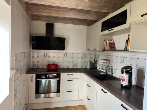 une cuisine avec des armoires blanches et des comptoirs noirs dans l'établissement Country home, à Saint-Ciers-sur-Bonnieure