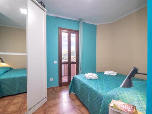 1 dormitorio con paredes azules, 1 cama y espejo en True paradise with a splendid panoramic terrace, en Porto Rotondo