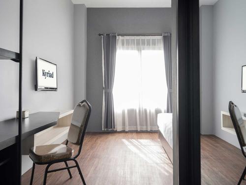a bedroom with a desk and a bed and a window at KYRIAD M2 LAMPUNG in Lampung