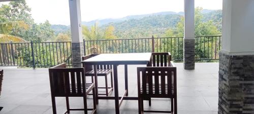 a table and chairs with a view of a balcony at Johans Villa Kandy in Kandy