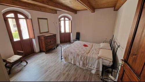 a bedroom with a bed and a dresser and two windows at Roccella Blu Holidays in Roccella Ionica