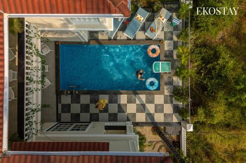 an overhead view of a pool with people swimming in it at EKOSTAY - Ezra Villa in Anjuna