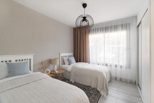a bedroom with two beds and a window at Casa Elegante Casares Costa Golf in Casares