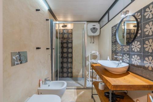 a bathroom with a sink and a toilet and a mirror at Gargallo Loft in Ortigia in Siracusa