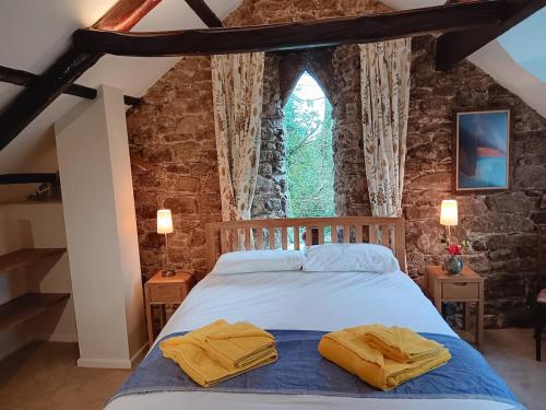 una camera da letto con un letto con due asciugamani gialli di Pandia Cottage a Bodmin