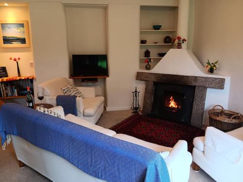 un soggiorno con divano e camino di Pandia Cottage a Bodmin
