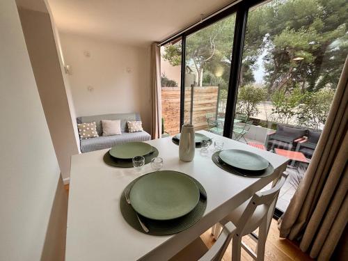 une table blanche avec deux plaques vertes au-dessus dans l'établissement T2 en rez-de-jardin avec terrasse privative, résidence avec piscine et tennis, à Six-Fours-les-Plages