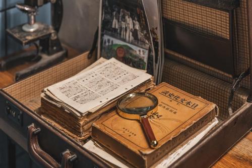 a pair of books and a magnifying glass on a table at Jiufen Ore Inn in Jiufen