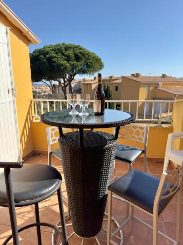 - une table avec une bouteille de vin sur le balcon dans l'établissement Original -5pers- Histoire de clés, au Cap d'Agde