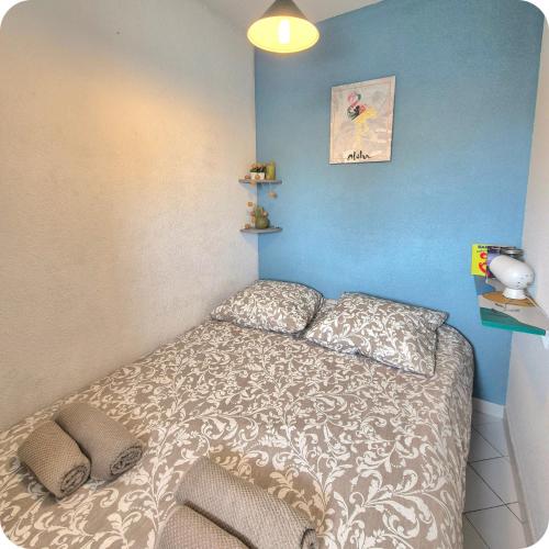 une chambre avec un lit et un mur bleu dans l'établissement T2 Terrasse - Garage - Vélos - A 3 minutes des plages, à La Grande Motte