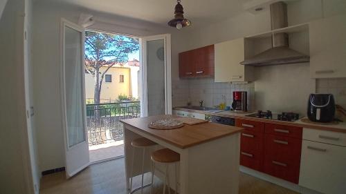 une cuisine avec un comptoir et une grande fenêtre dans l'établissement Maison familiale à Perpignan, à Perpignan