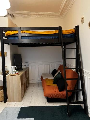 une chambre avec deux lits superposés et un bureau dans l'établissement Studio cosy proche Père-Lachaise, à Paris