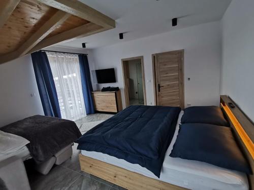 a bedroom with a large bed with blue sheets at MelVille in Ružomberok