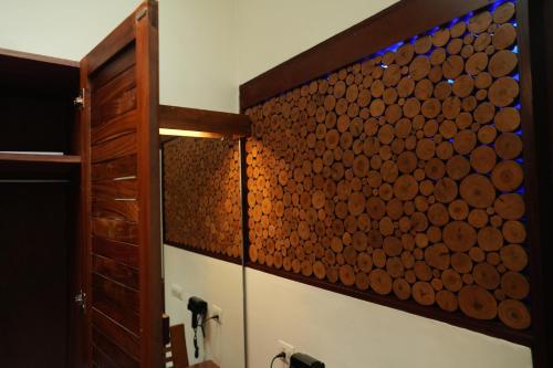 a bathroom with a wall of wooden logs at Wayanad Silverwoods Forest Resort & Spa in Padinjarathara