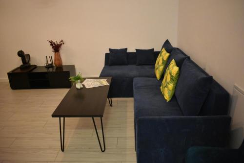 a living room with a blue couch and a table at Wald Central Residence in Rădăuţi