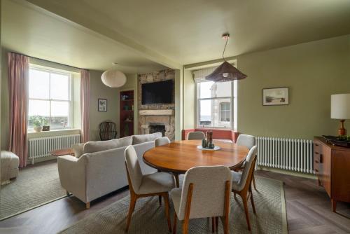 a living room with a table and a couch at Ledgers Cottage- Harbourfront Home Pittenweem in Pittenweem